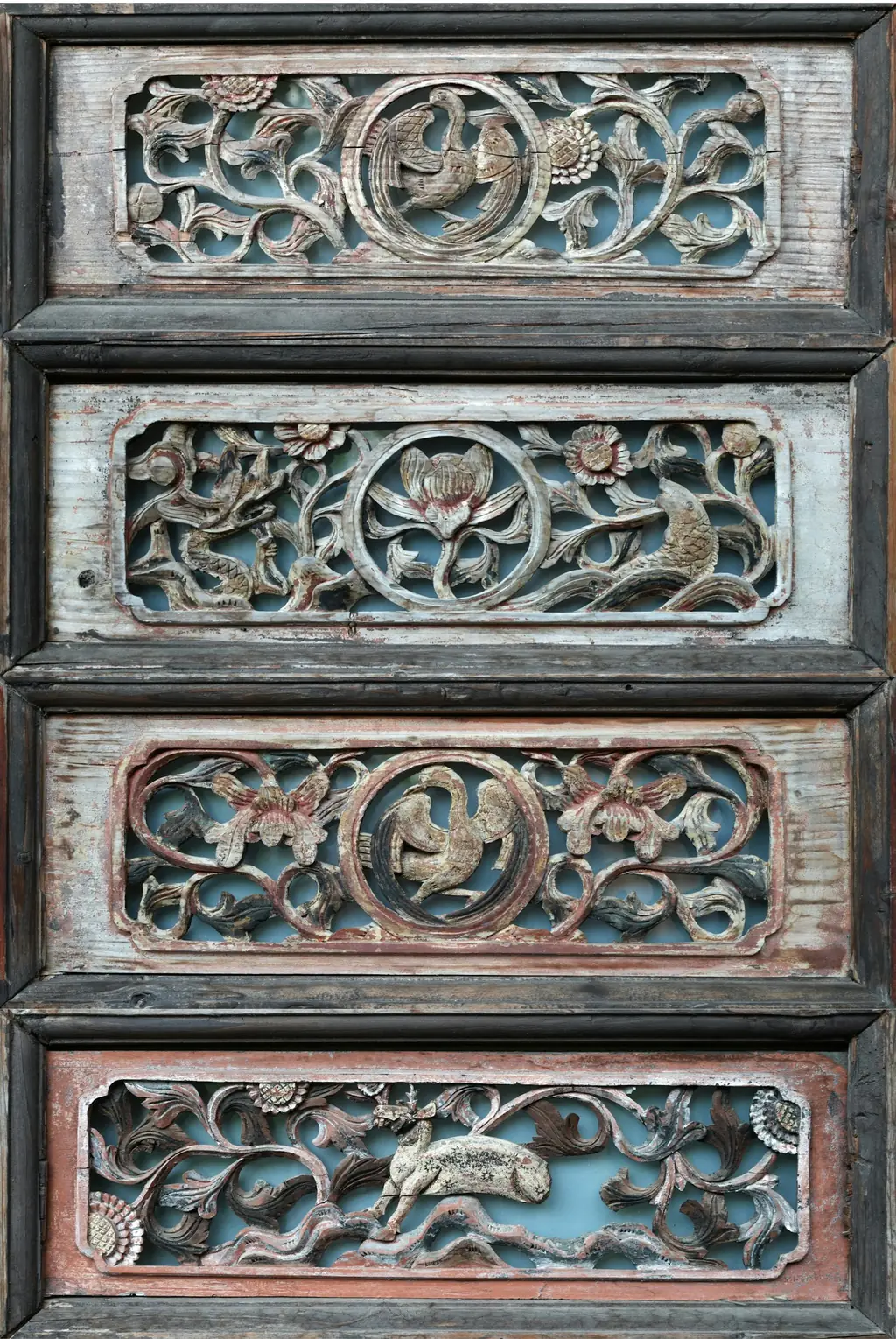 Four carved wooden panels with floral motifs