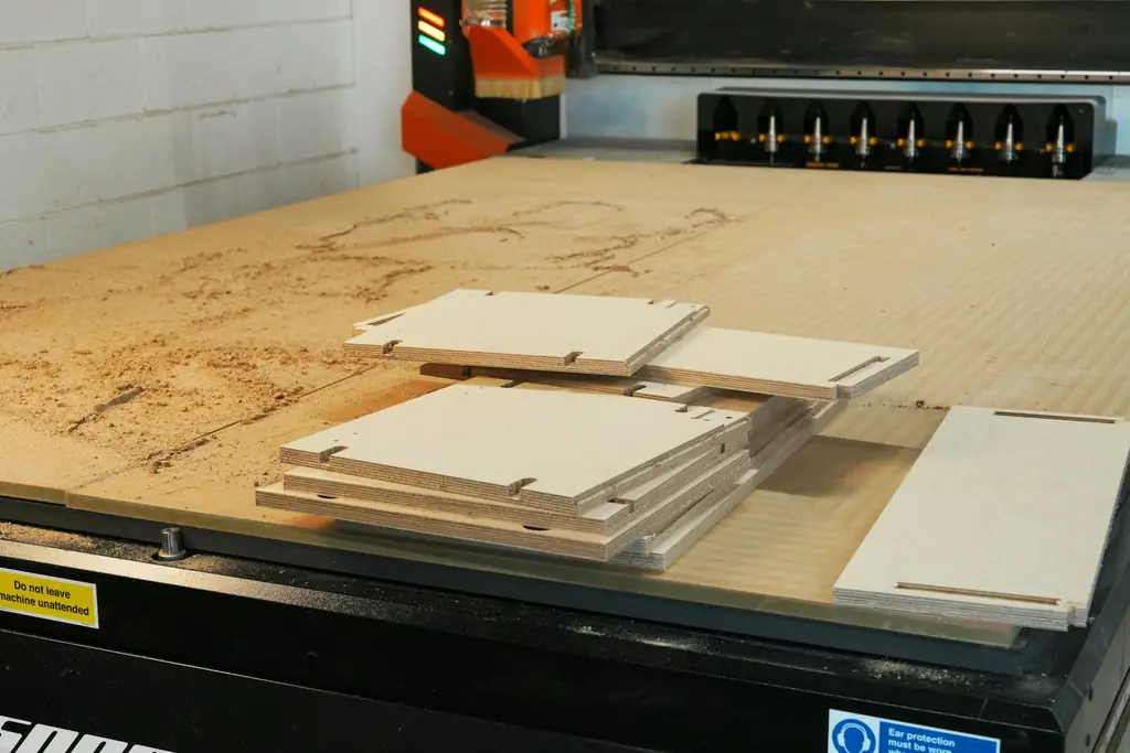Cut wooden pieces on a CNC machine bed