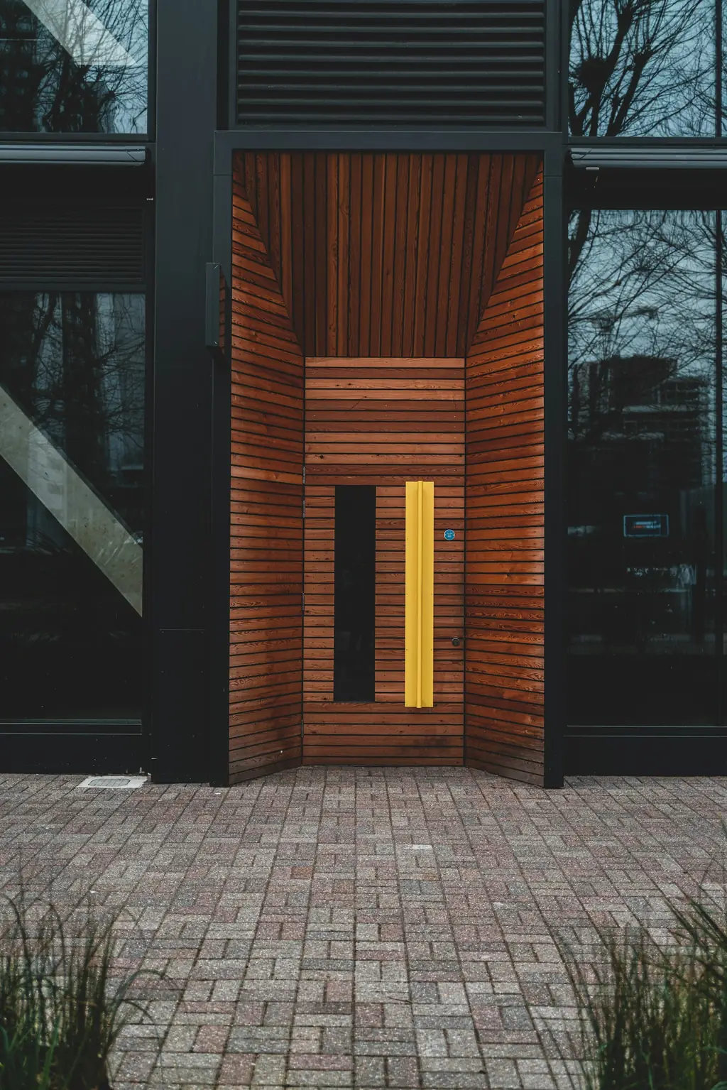 Contemporary wooden entrance door with a tall handle