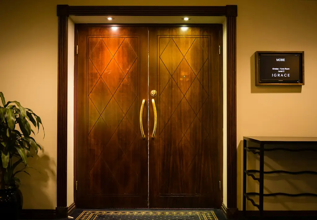 Polished wooden double door with brass handles